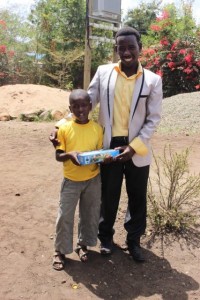 Praygod and his Dad with gift from his sponsors